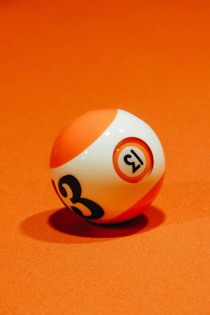 Billiard ball with number on bright orange surface for complex intellectual board game